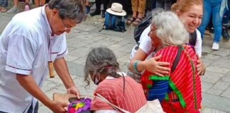 Turistas realizan colecta en desfile de delegaciones para apoyar a mujeres Triquis